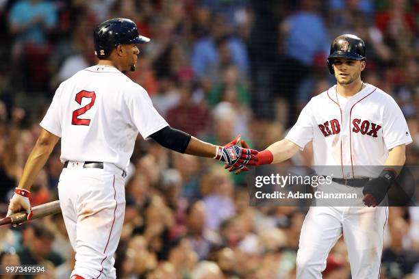 Andrew Benintendi of the Boston Red Sox high fives Xander Bogaerts of the Boston Red Sox after scoring in the third inning of a game against the...