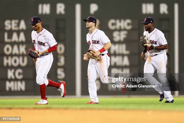 Mookie Betts, Andrew Benintendi and Jackie Bradley Jr. #19 of the Boston Red Sox react after a victory over the Texas Rangers at Fenway Park on July...