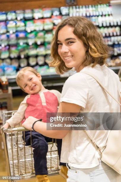 jeune femme et son fils épicerie dans un supermarché - juanmonino photos et images de collection