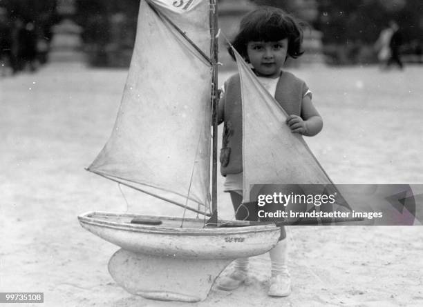 Girl with toy sailing-ship at Jardin du Luxembourg. Paris. Photograph. Around 1930.