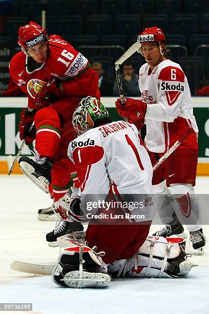 Mikhail Stefanovich of Belarus jumps in the air infront of goaltender Patrick Galbraith and Stefan Lassen of Denmark during the IIHF World...