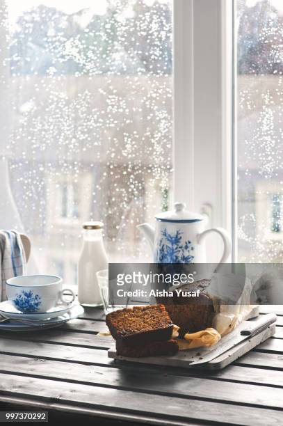 ginger loaf and coffee on a table beside a rain-splattered window. - aisha stock-fotos und bilder