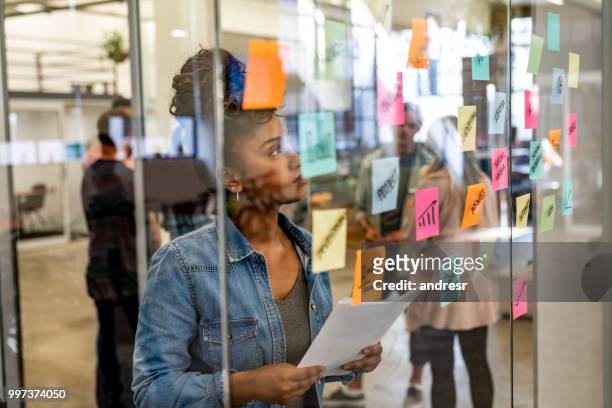 thoughtful woman brainstorming at a creative office - group people thinking stock pictures, royalty-free photos & images