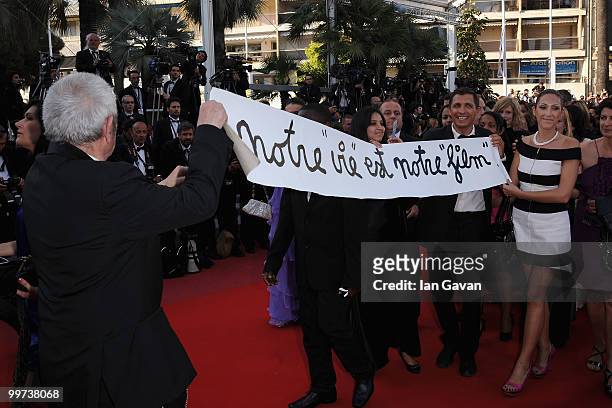 French artist, Ben holds a banner reading 'Our life is our film' at the "Biutiful" Premiere at the Palais des Festivals during the 63rd Annual Cannes...
