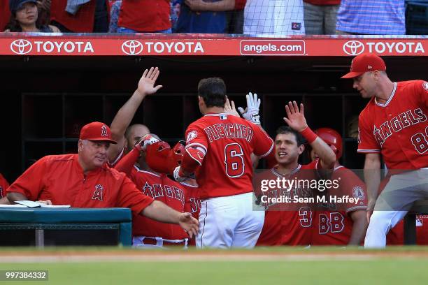 Manager Mike Scioscia, Ian Kinsler and Albert Pujols congratulate David Fletcher of the Los Angeles Angels of Anaheim after his solo homerun during...