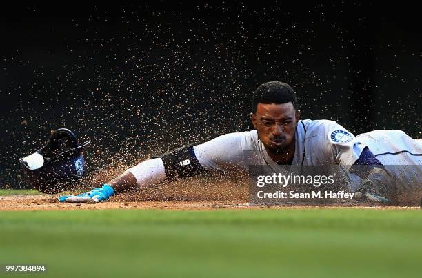 Dee Gordon slides safely at home scoring on an RBI single hit by Kyle Seager of the Seattle Mariners during the first inning of a game against the...