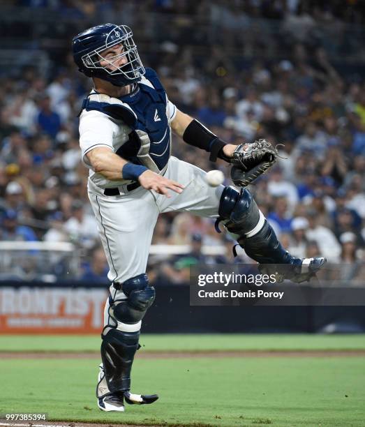 Austin Hedges of the San Diego Padres throws to first base on a ball hit by Cody Bellinger of the Los Angeles Dodgers during the fourth inning of a...