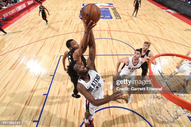 Caleb Swanigan of the Portland Trail Blazers and Omari Spellman of the Atlanta Hawks reach for the ball during the 2018 Las Vegas Summer League on...