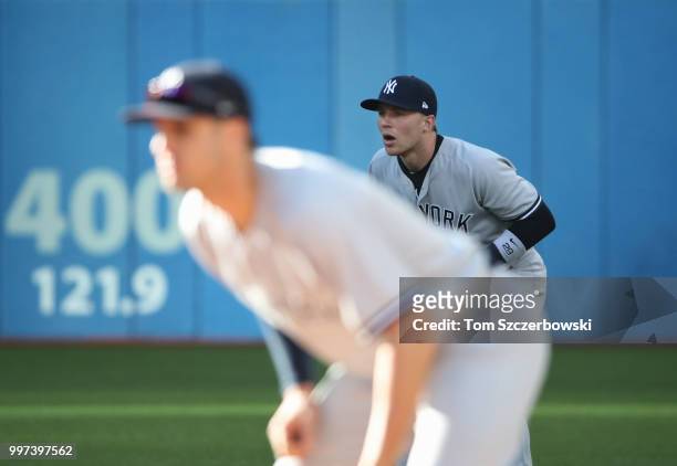 Brandon Drury of the New York Yankees looks on from his position in the field at second base as Greg Bird can be seen in the foreground during MLB...