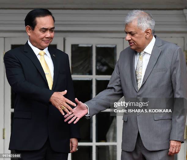 Sri Lanka's Prime Minister Ranil Wickremesinghe and Thailand's Prime Minister Prayut Chan-O-Cha shake hands during a meeting at the prime minister's...