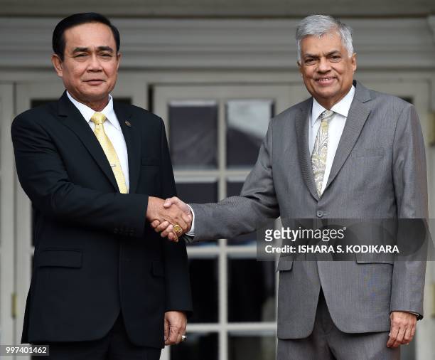 Sri Lanka's Prime Minister Ranil Wickremesinghe and Thailand's Prime Minister Prayut Chan-O-Cha shake hands during a meeting at the prime minister's...