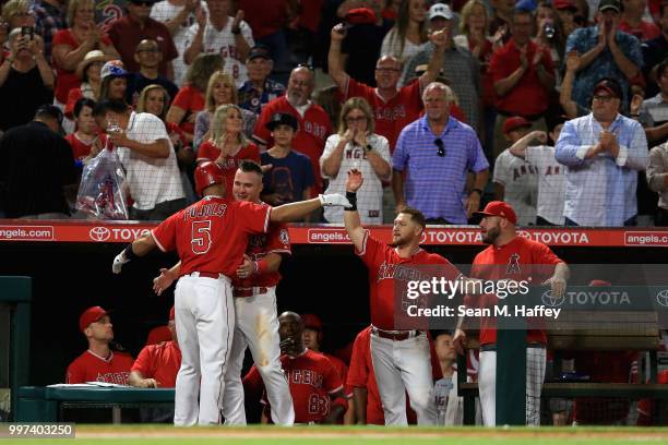 Kole Calhoun and Mike Trout congratulate Albert Pujols of the Los Angeles Angels of Anaheim at the dugout after his solo homerun during the sixth...