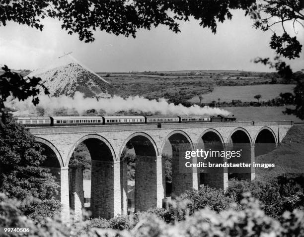 Train passing viaduct. The picture shows a train of the Great Western Railway passing over a viaduct on its speedy way to Paddington. Cornwall....