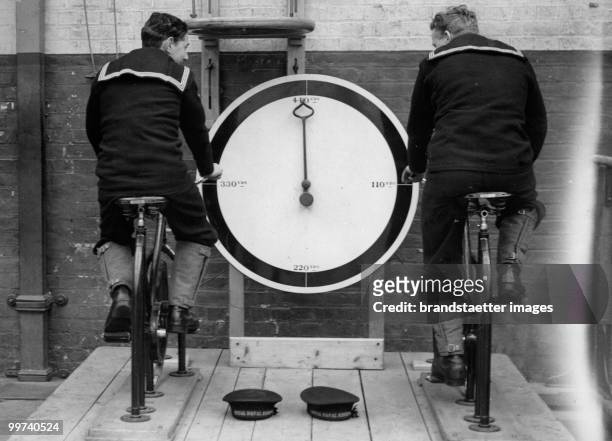 Royal Navy Daily Exercise. The picture shows two inductees of the royal navy training with the stationary cycle. Portsmouth. Photograph. Around 1930....