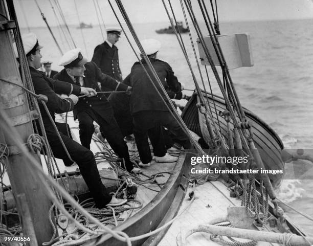 Young Naval officers ready for their trip are heaving the dinghy inboard. Photograph. 1935. (Photo by Austrian Archives