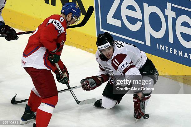 Kristaps Sotnieks of Latvia is challenged by Tomas Mojzis of Czech Republic during the IIHF World Championship group F qualification round match...