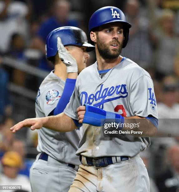 Chris Taylor of the Los Angeles Dodgers is congratulated by Enrique Hernandez of the Los Angeles Dodgers after scoring during the seventh inning of a...