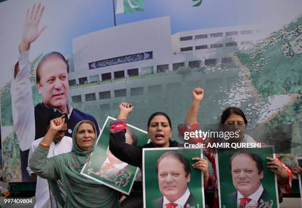Supporters of Pakistan's ousted prime minister Nawaz Sharif hold posters of him and chant slogans as they gather at the venue where his younger...