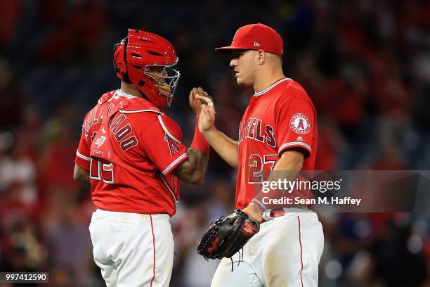 Mike Trout and Martin Maldonado of the Los Angeles Angels of Anaheim celebrate defeating the Seattle Mariners 11-2 in a game at Angel Stadium on July...