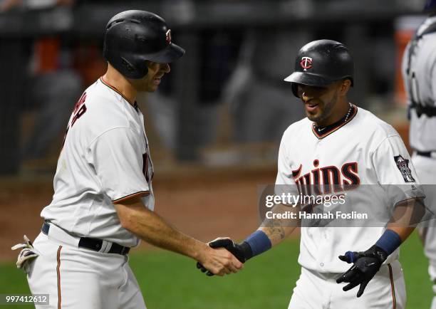 Joe Mauer of the Minnesota Twins congratulates teammate Eddie Rosario on a two-run home run against the Tampa Bay Rays during the seventh inning of...
