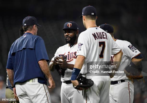 Manager Paul Molitor and Joe Mauer of the Minnesota Twins check on Fernando Rodney after being hit by the ball during the ninth inning of the game...