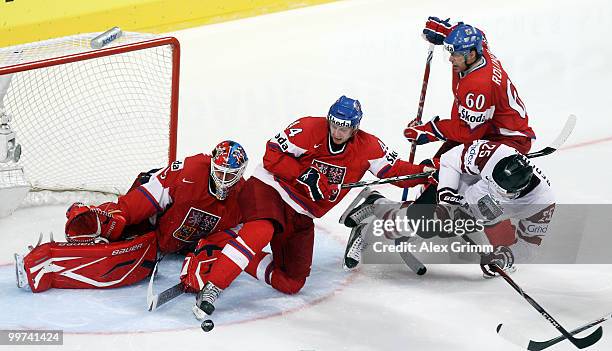 Jekabs Redlihs of Latvia tries to score against goaltender Tomas Vokoun, Miroslav Blatak and Tomas Rolinek of Czech Republic during the IIHF World...