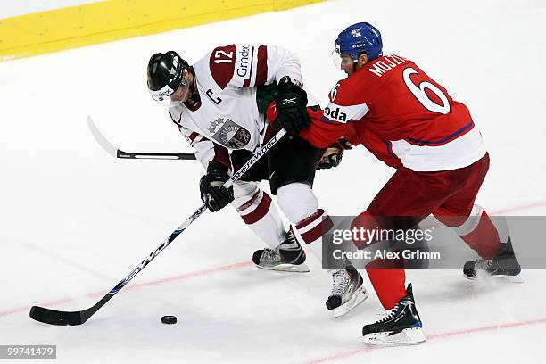 Herberts Vasiljevs of Latvia is challenged by Tomas Mojzis of Czech Republic during the IIHF World Championship group F qualification round match...
