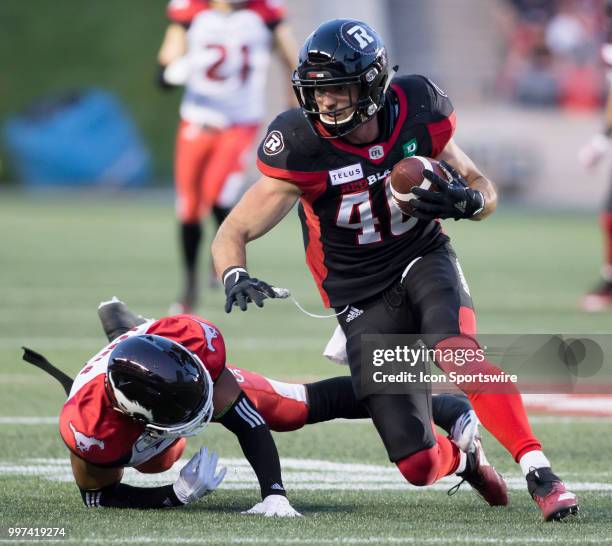 Jean-Christophe Beaulieu of the Ottawa Redblacks tries to stay on his feet after making a reception against the Calgary Stampeders in a regular...