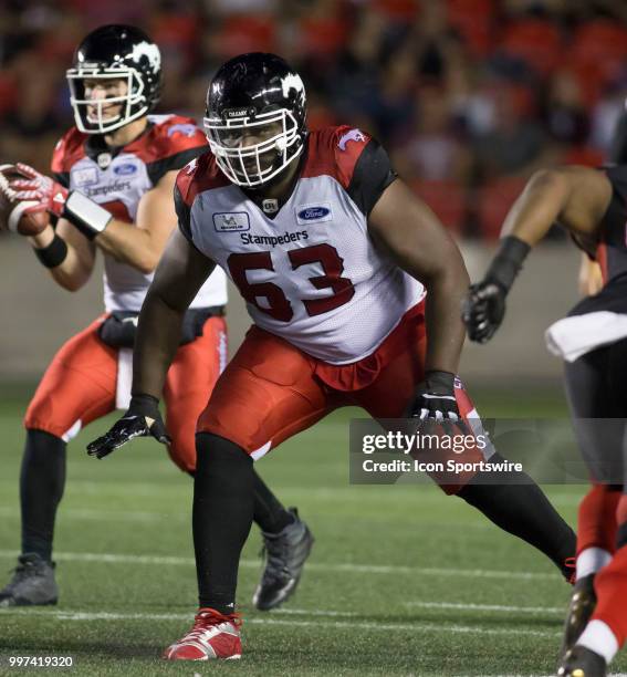 Derek Dennis of the Calgary Stampeders wards off the Ottawa Redblacks in a regular season Canadian Football League game played at TD Place Stadium in...