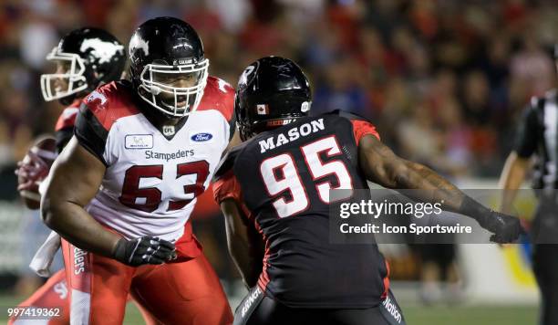 Derek Dennis of the Calgary Stampeders wards off the Ottawa Redblacks rush in a regular season Canadian Football League game played at TD Place...