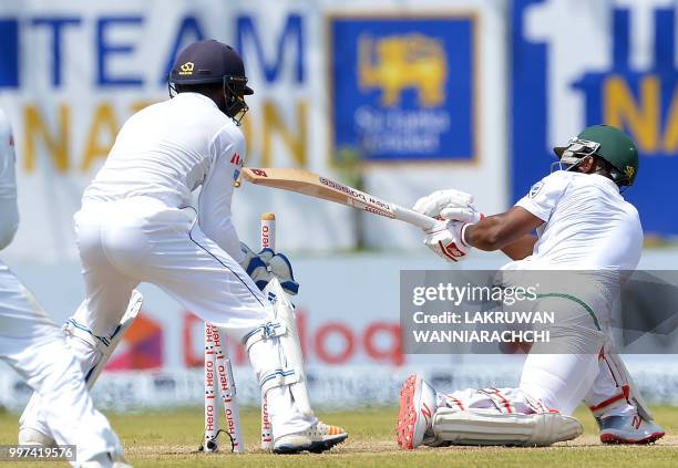 South Africa's Temba Bavuma is dismissed by Sri Lankan spinner Lakshan Sandakan as wicketkeeper Niroshan Dickwella reacts during the second day of...