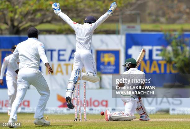 South Africa's Temba Bavuma is dismissed by Sri Lankan spinner Lakshan Sandakan as wicketkeeper Niroshan Dickwella reacts during the second day of...