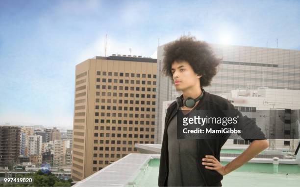 young man standing rooftop - mamigibbs stockfoto's en -beelden