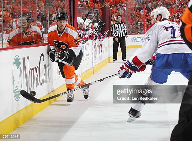 Darroll Powe of the Philadelphia Flyers shoots the puck past Hal Gill of the Montreal Canadiens in Game One of the Eastern Conference Finals during...