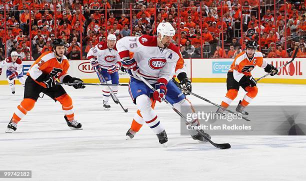 Hal Gill of the Montreal Canadiens skates the puck between Dan Carcillo and Mike Richards of the Philadelphia Flyers in Game One of the Eastern...