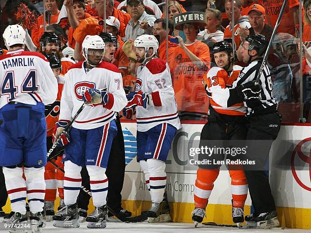 Dan Carcillo of the Philadelphia Flyers is restrained by Linesmen Steve Miller during a scrum against Roman Hamrlik, PK Subban and Mathieu Darche of...