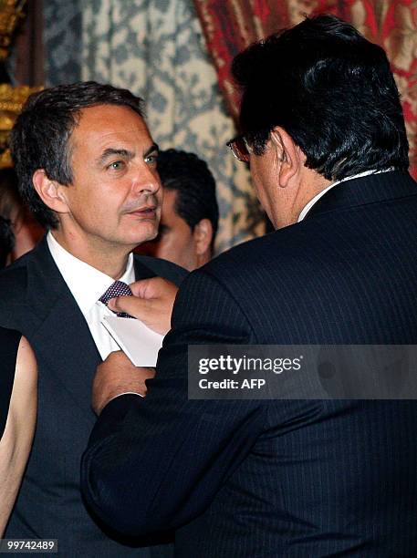 Peru's President Alan Garcia adjusts Spanish Prime Minister Jose Luis Rodriguez Zapatero' s tie during a gala dinner at The Royal Palace in Madrid on...