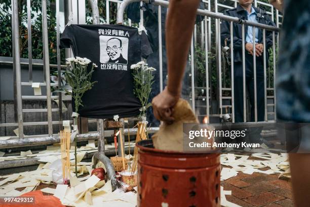 Protester burns paper offering in front of a makeshift altar for Liu Xiaobo on July 13, 2018 in Hong Kong, Hong Kong. July 13 marks one year...