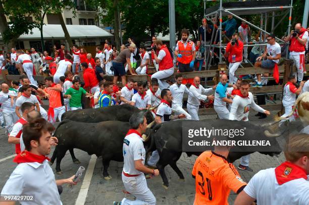 Participants run next to a Jandilla fighting bull on the seventh bullrun of the San Fermin festival in Pamplona, northern Spain on July 13, 2018. -...