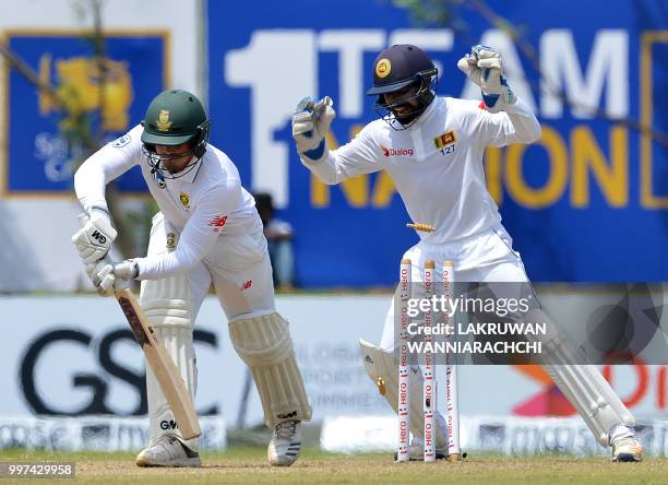 South Africa's Quinton de Kock is dismissed by Sri Lanka's Dilruwan Perera as wicketkeeper Niroshan Dickwella reacts during the second day of the...