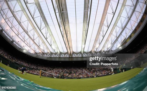 View of Centre Court with the roof closed as Andy Murray of Great Britain serves on Day One of the Wimbledon Lawn Tennis Championships at the All...