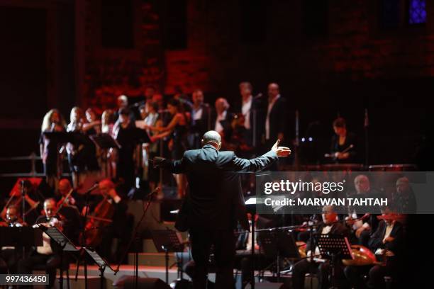 Lebanese artist Hani Siblini conducts the orchestra during Lebanese artist Ziad Rahbani's concert at the Beiteddine Palace in Lebanon's Chouf...