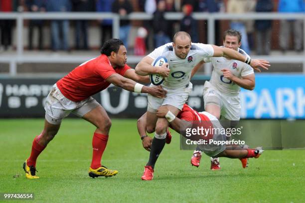 Charlie Sharples of England Saxons is tackled by the Tonga defence during the Churchill Cup match between England Saxons and Tonga at Kingsholm in...