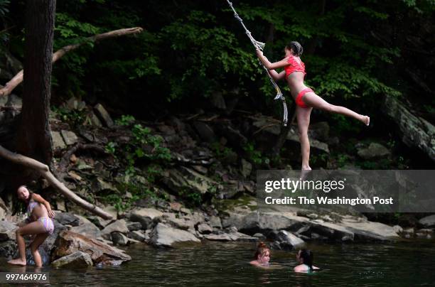 Leigh Ann Cherry left, watches as Trinity Hunt uses a rope to swing into Passage Creek in George Washington National Forest on Wednesday July 11,...