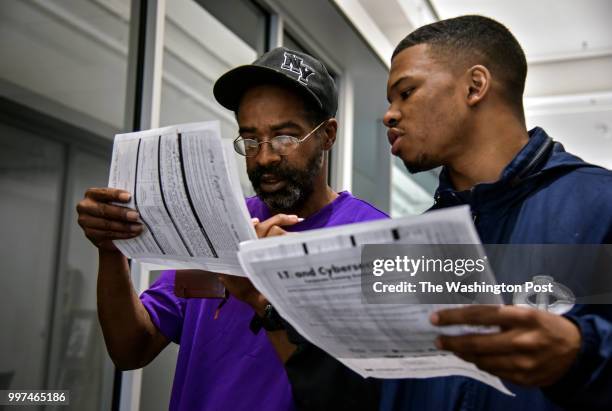 During a weeklong job training program, Keith Mitchell, Jr., L, and Isaiah Hall excitedly look over the class lists of IT certification programs at...