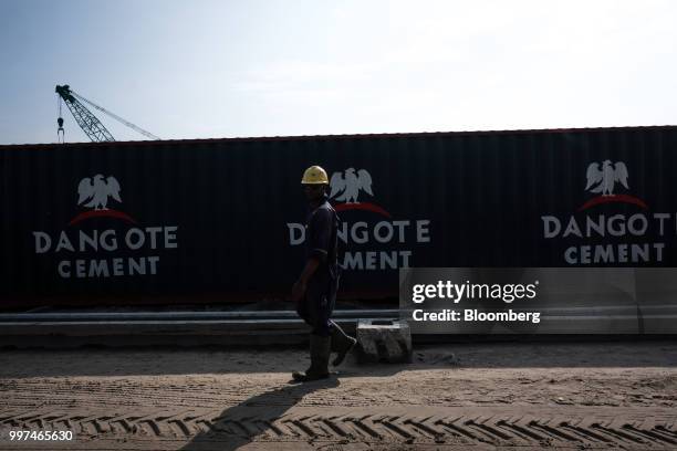 The Dangote Cement Plc logo stands on a barrier at the under-construction Dangote Industries Ltd. Oil refinery and fertilizer plant site in the Ibeju...