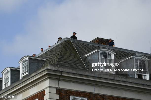 Security look out from the roof as US President Donald Trump leaves the US ambassador's residence Winfield House in London on July 13, 2018. - US...