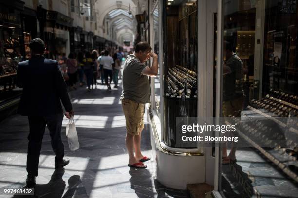 Shopper looks at the window display of a luxury store at the Burlington Arcade in central London, U.K., on Friday, Jun. 29, 2018. Nevermind West End...