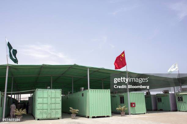 Pakistani and Chinese national flag fly next to containers at a workers camp, operated by China Overseas Ports Holding Co., in Gwadar, Balochistan,...