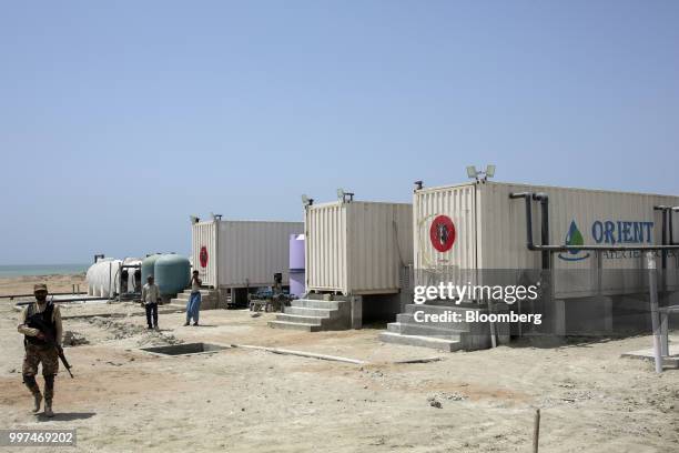 Member of the security forces walks through a desalination plant in Gwadar, Balochistan, Pakistan, on Monday, July 3, 2018. What used to be a small...